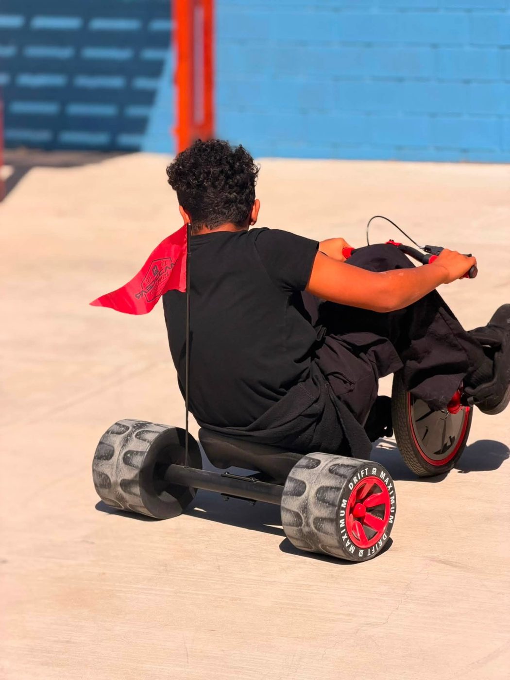 Child riding a trike on the campus playground