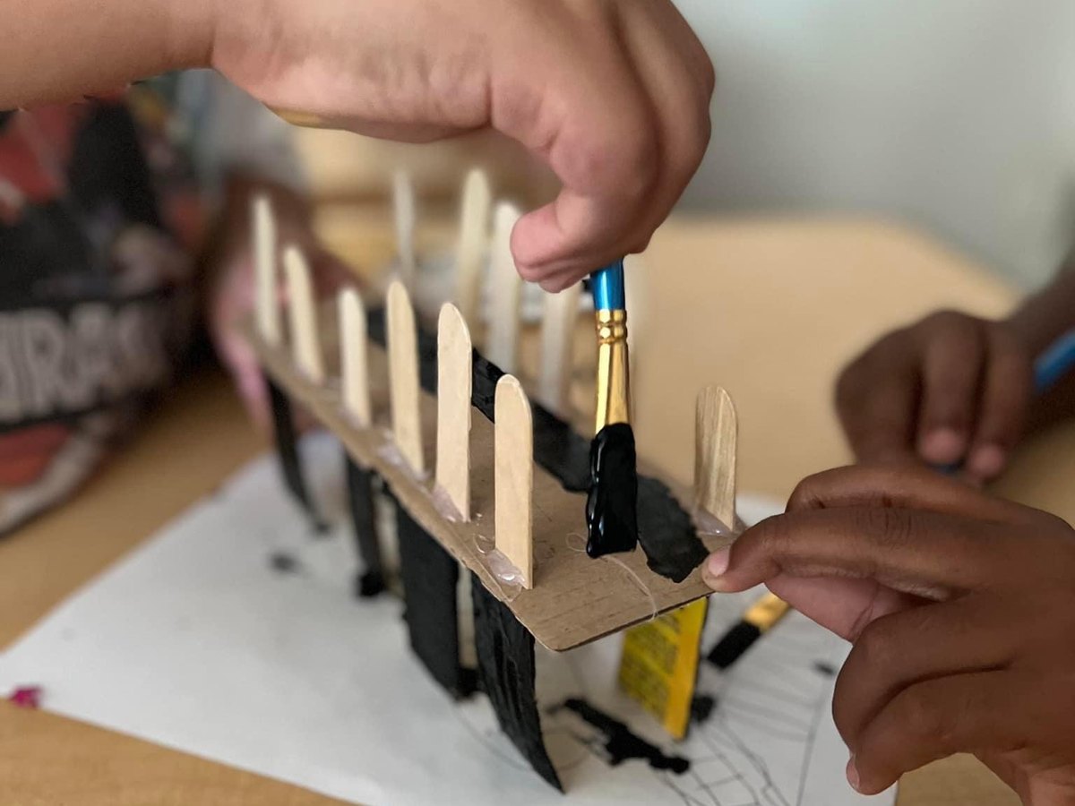 Students building a structure with craft sticks