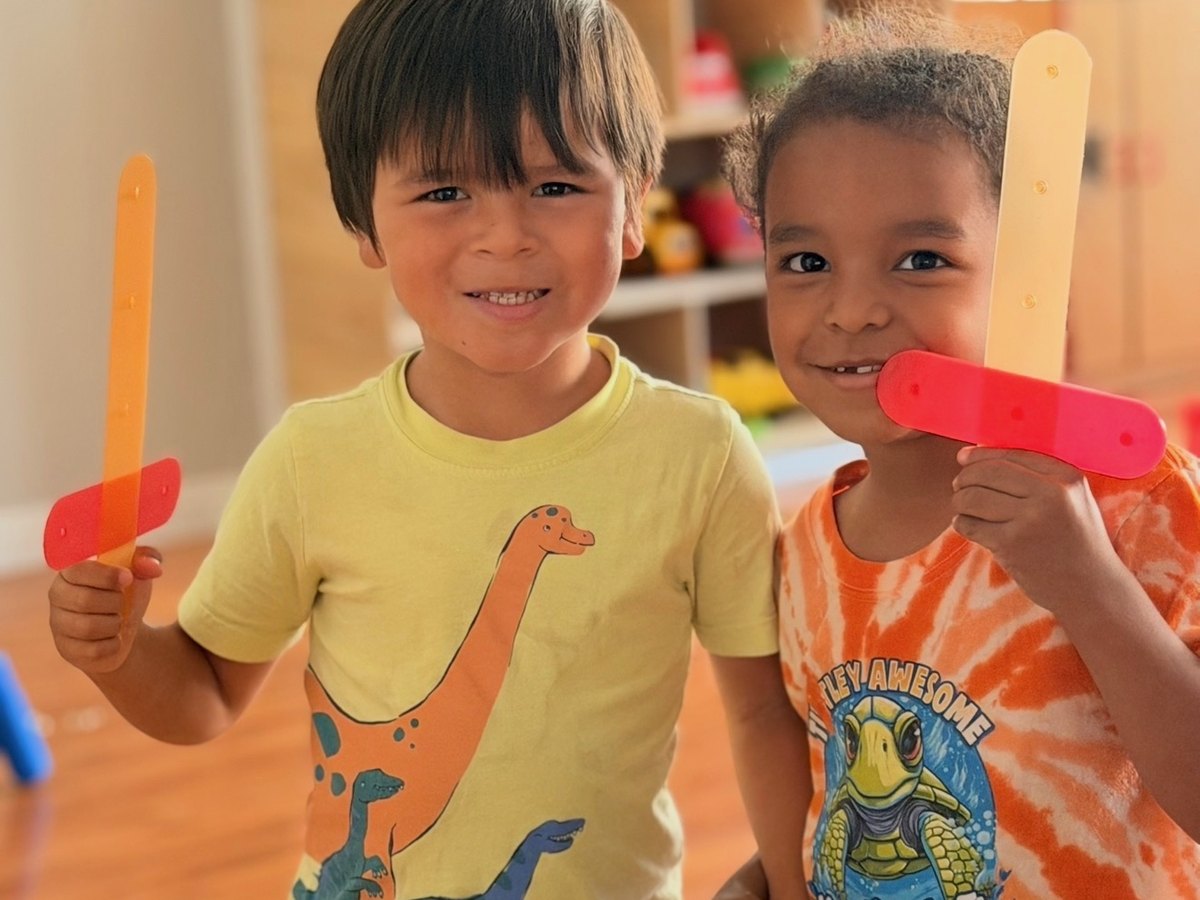Two friends showing off their foam craft sticks