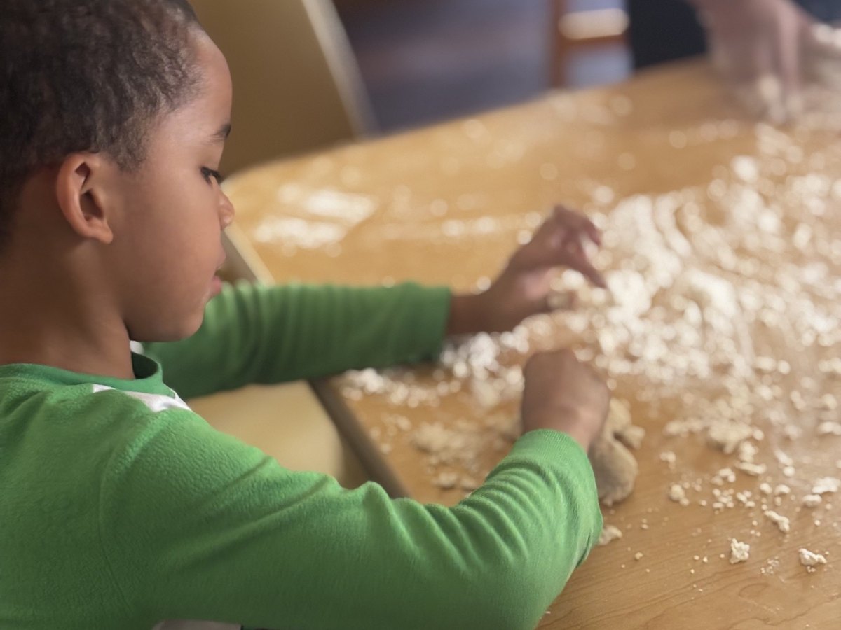 A child exploring a flour sensory table