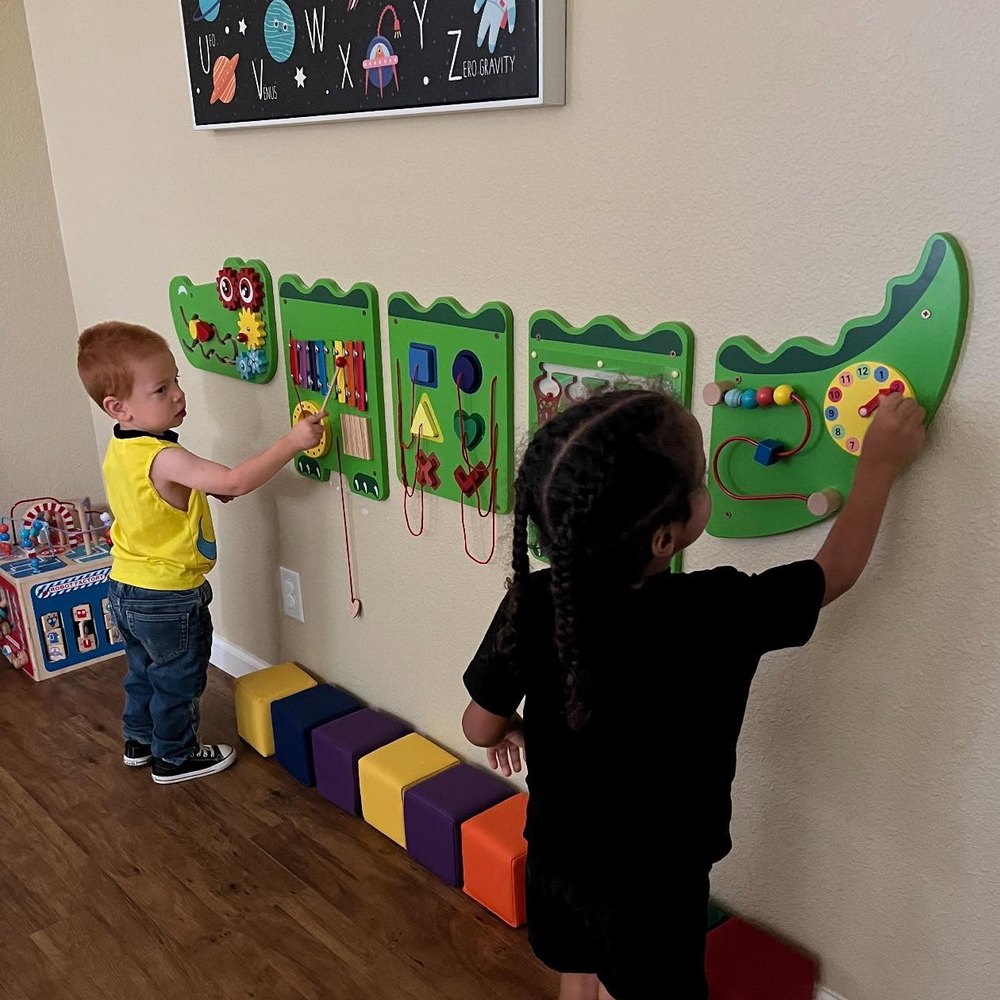 Children playing at the classroom busy wall