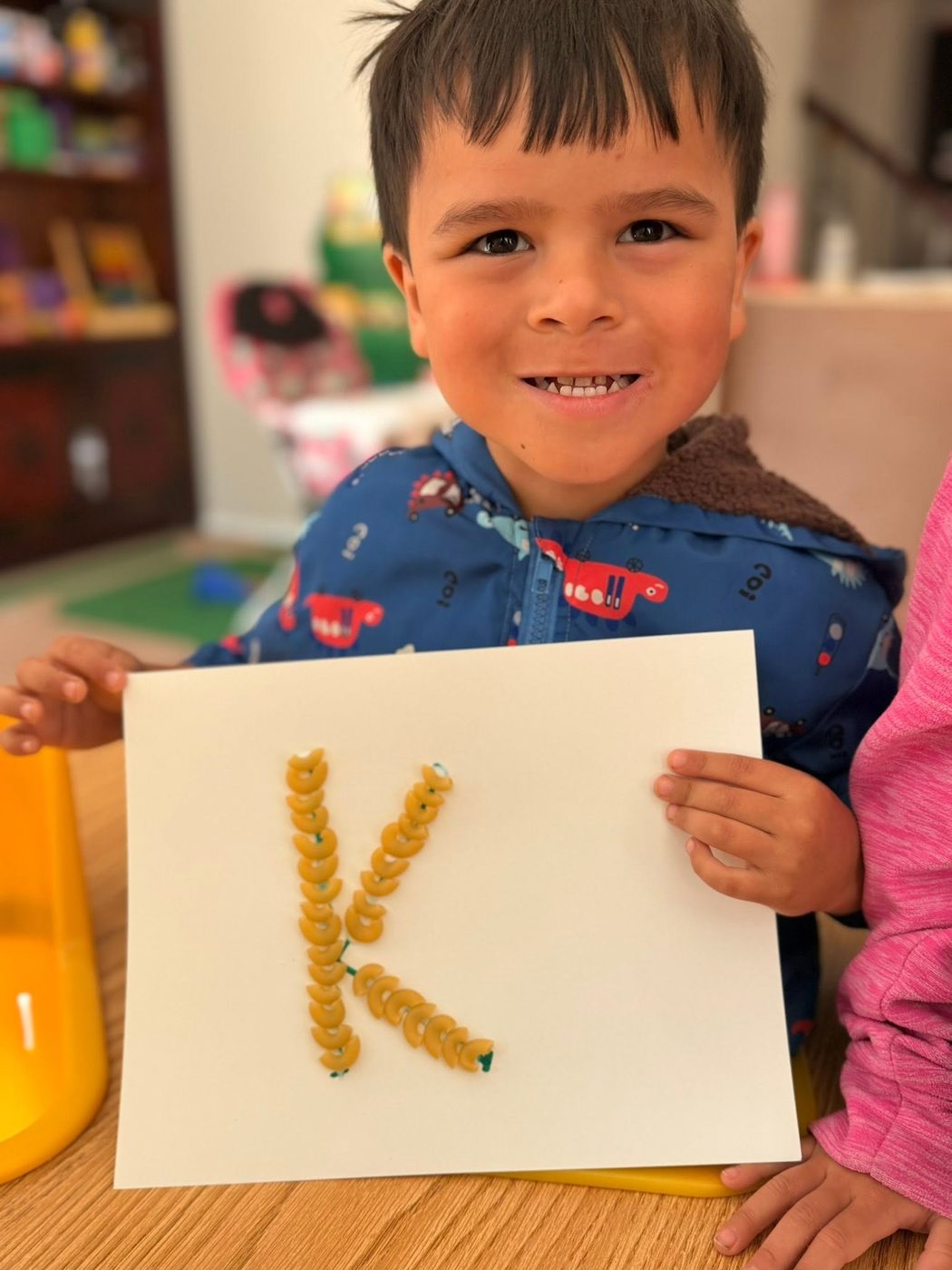 A child holding a letter craft