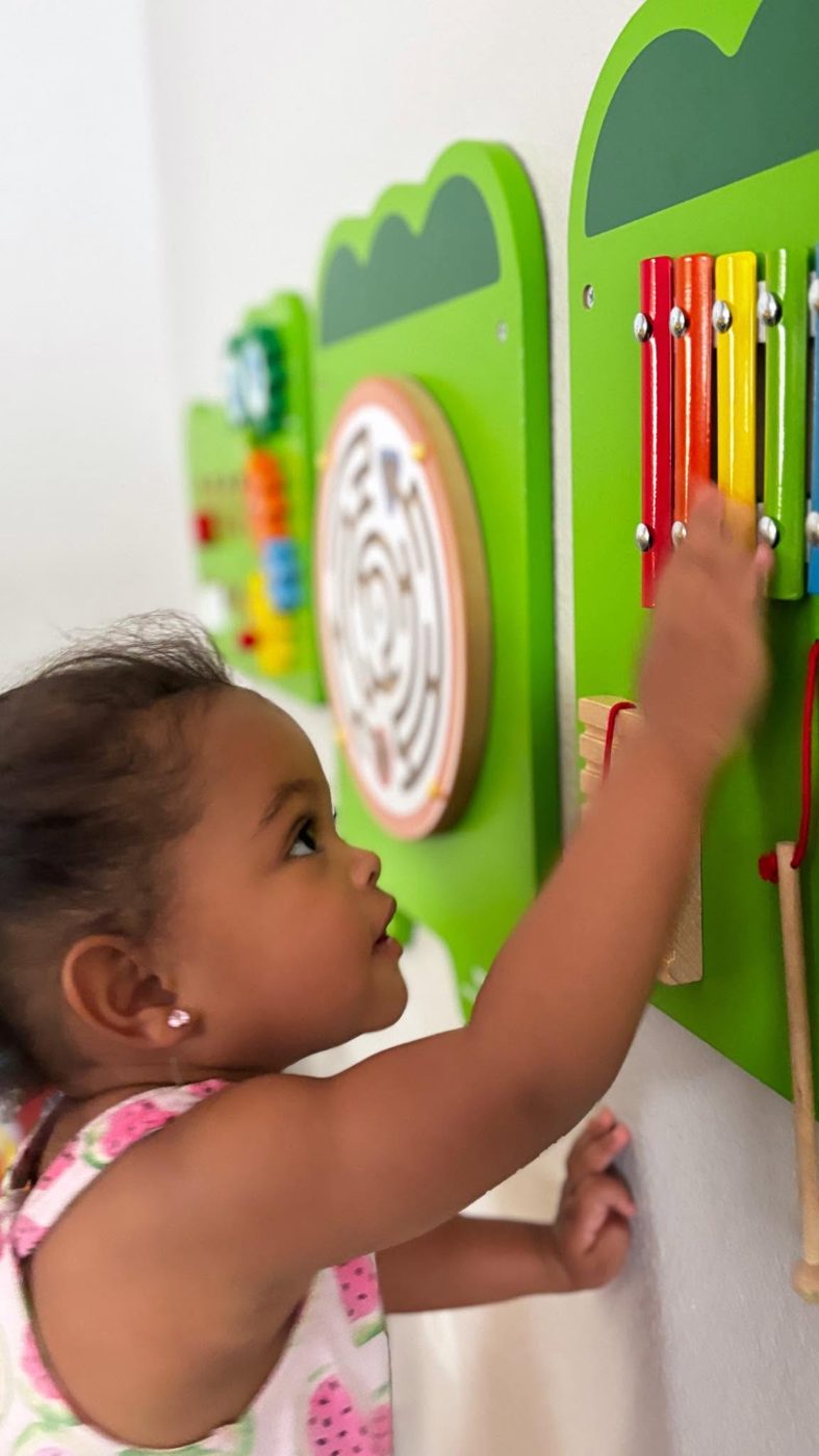 A toddler exploring the busy board