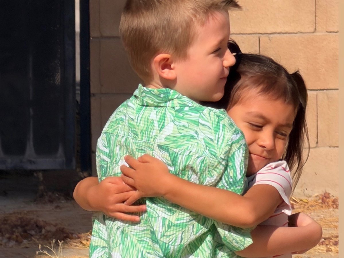 Two friends sharing a hug outside